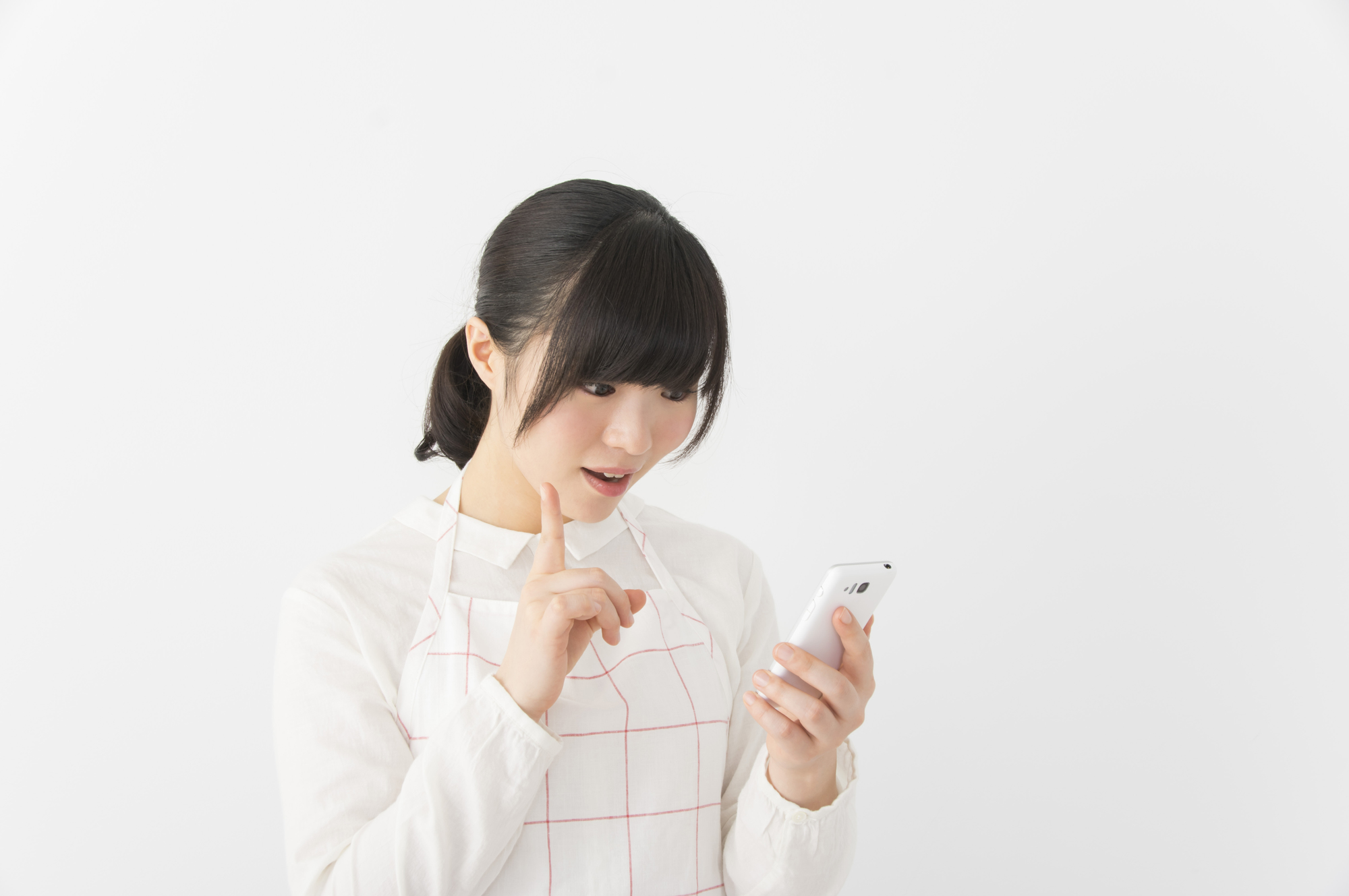 スマホを見て驚く女性